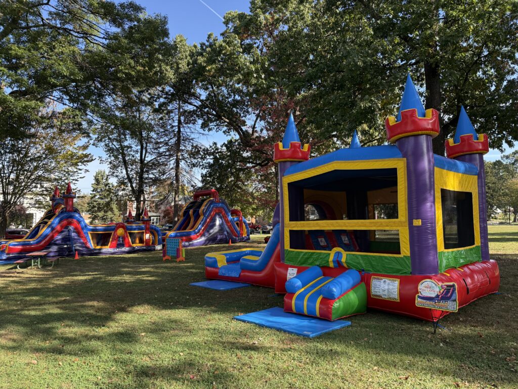 multiple inflatable rentals set up at a park